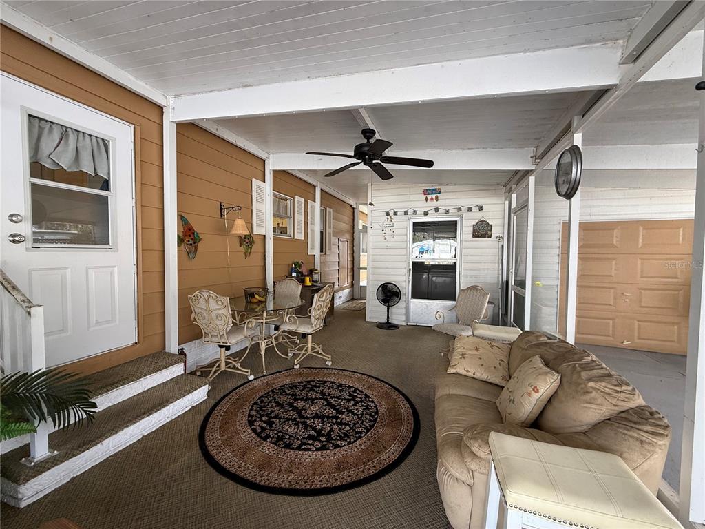 A covered outdoor patio features a seating area, a dining set, and a ceiling fan — 50 N BOBWHITE ROAD, WILDWOOD, FL