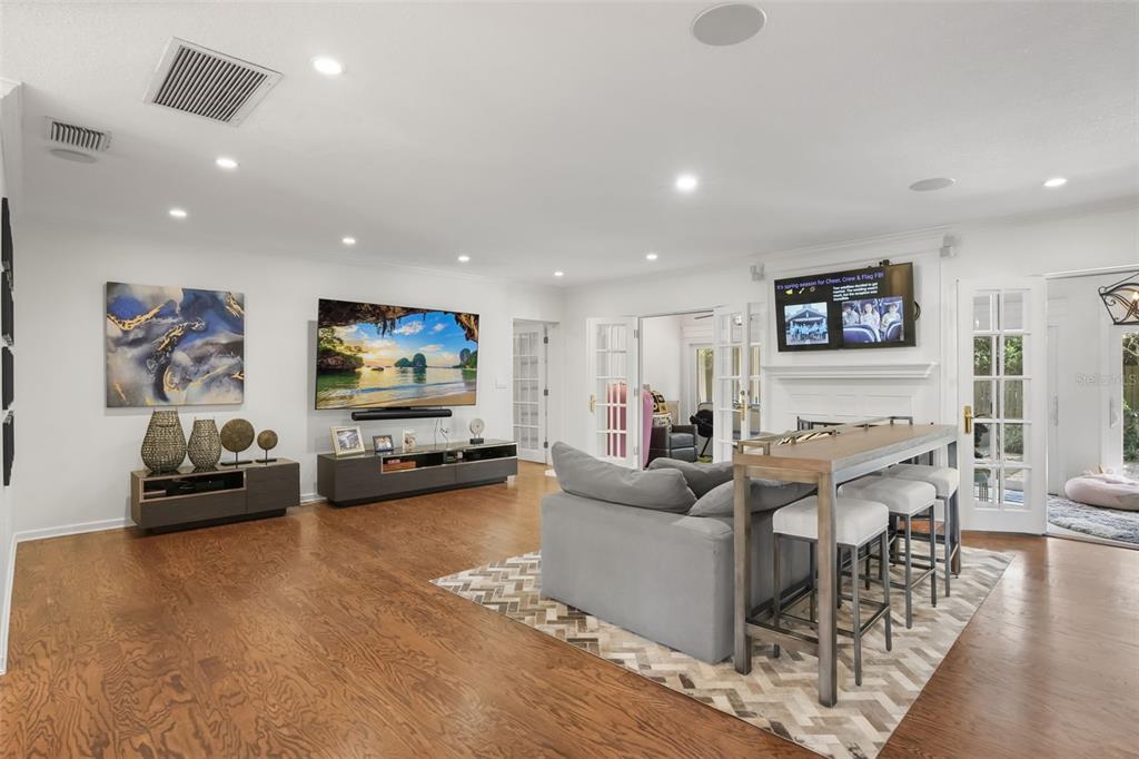 A living room features hardwood floors, a large television, a sofa, and a console table — 119 HOLLIE COURT, MAITLAND, FL