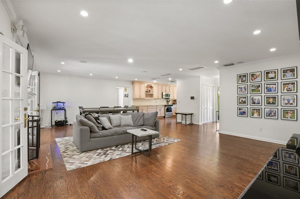 A spacious living room with hardwood floors, a grey sofa, and a gallery wall — 119 HOLLIE COURT, MAITLAND, FL