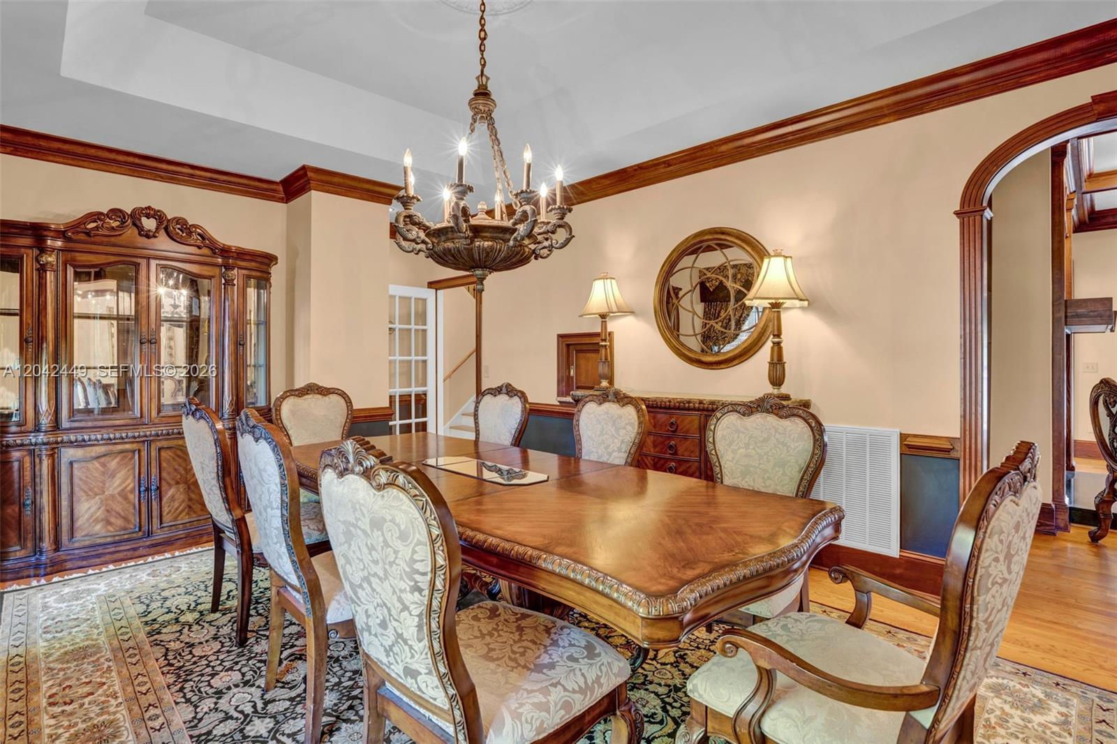 A formal dining room features a wooden table, upholstered chairs, a chandelier, and wood trim — 2579 Grey Rabbit Run, NC 27205, NC