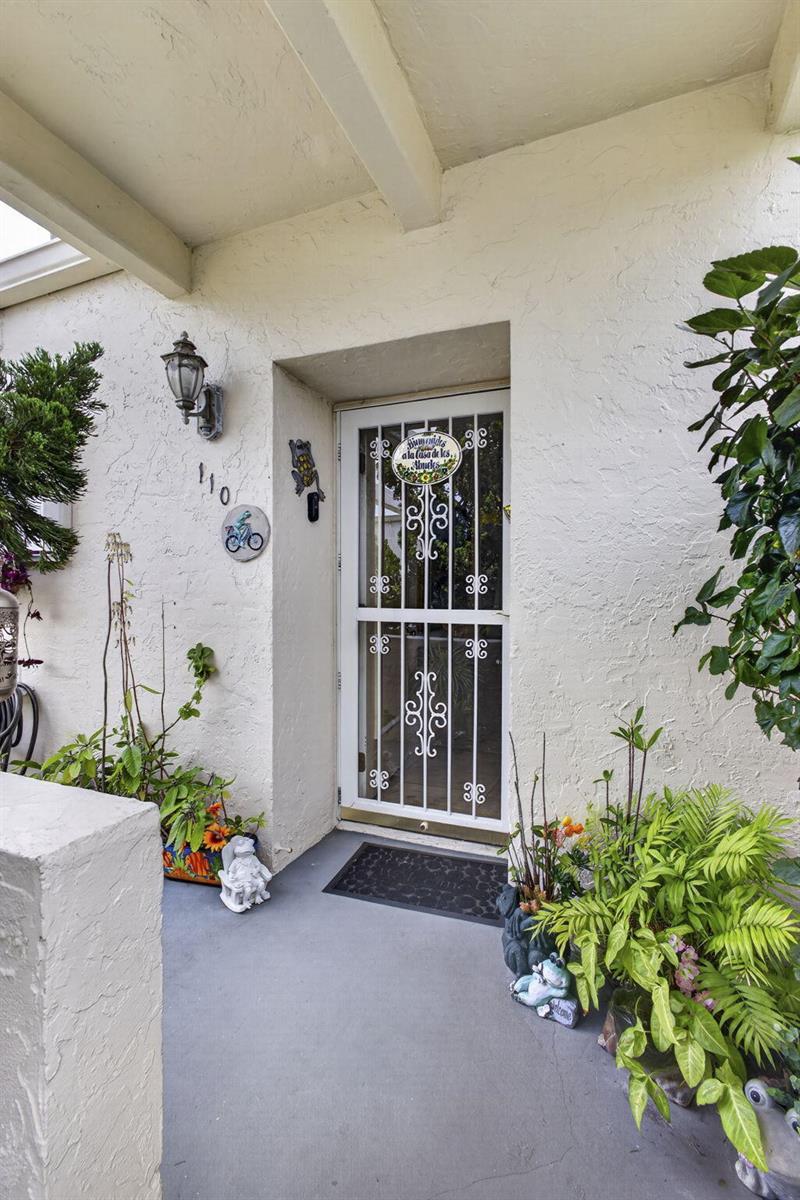 A white front door with a decorative security screen sits on a covered porch — 2651 Boundbrook Boulevard # 110, West Palm Beach FL 33461, WEST PALM BEACH, FL