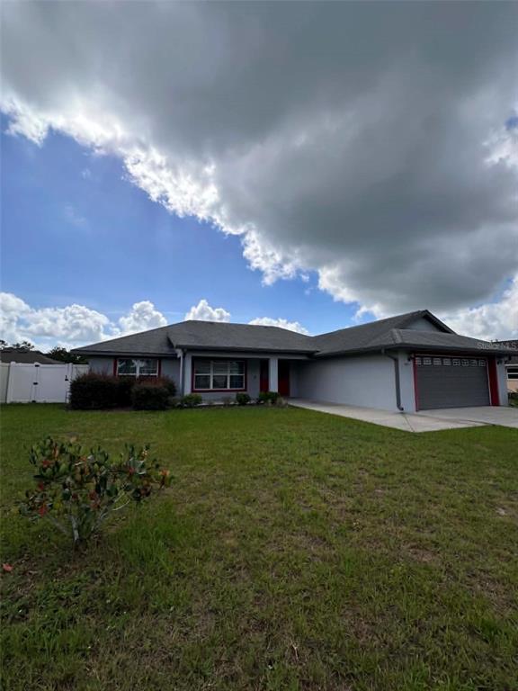 A single-story house with a gray exterior, red trim, and an attached two-car garage — 999 SE 69TH AVENUE, OCALA, FL