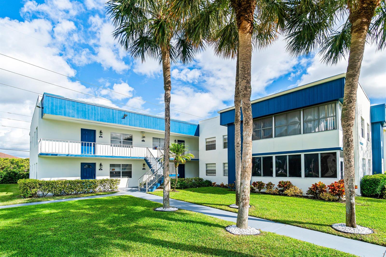 A two-story apartment building with blue trim, white walls, and palm trees on the lawn — 508 Normandy K # 508, Delray Beach FL 33484, DELRAY BEACH, FL