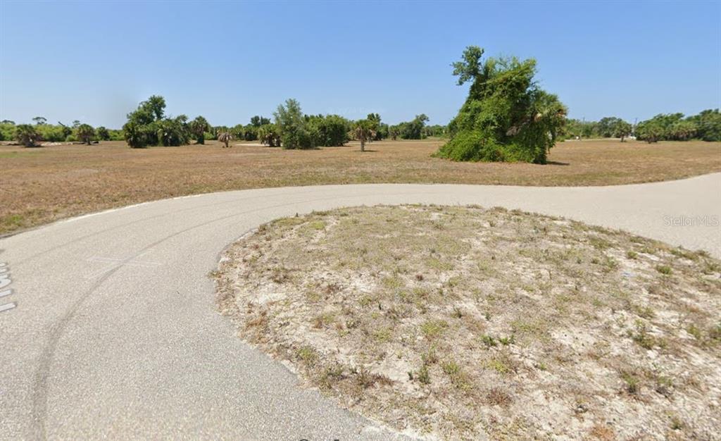 A paved cul-de-sac curves around a sandy lot surrounded by trees and brush — 21 HULL COURT, PLACIDA, FL