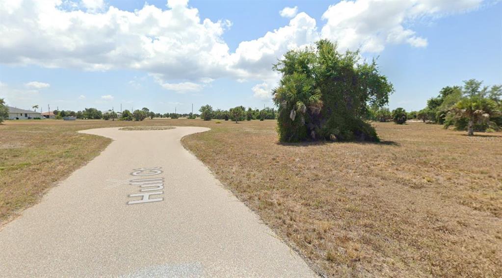 A paved cul-de-sac turnaround sits in the middle of a large, undeveloped grassy lot — 21 HULL COURT, PLACIDA, FL