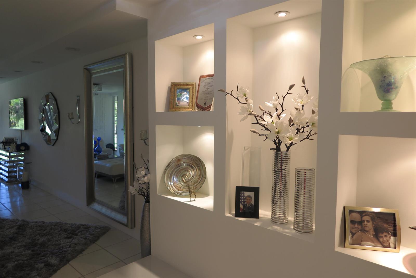 A hallway features white built-in wall niches displaying decorative items and a large floor mirror — 7875 La Mirada Drive, Boca Raton FL 33433, BOCA RATON, FL