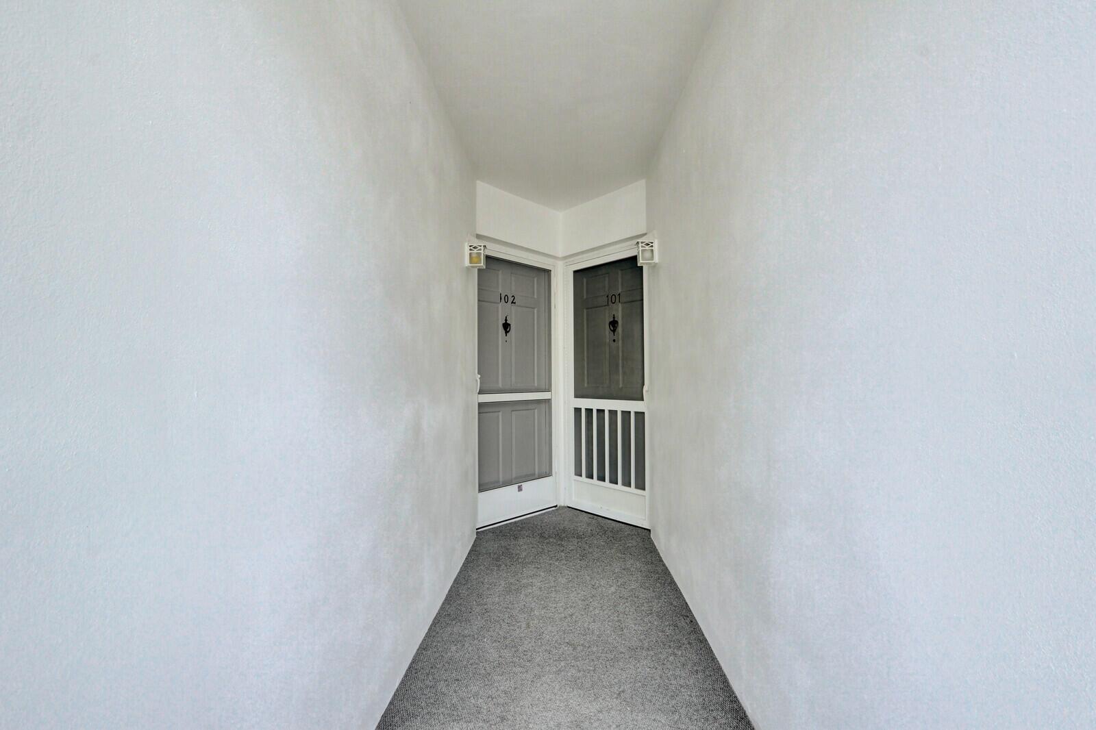 A narrow hallway features gray carpet and two doors labeled 101 and 102 — 9 Westwood Avenue # 102b, Tequesta FL 33469, TEQUESTA, FL