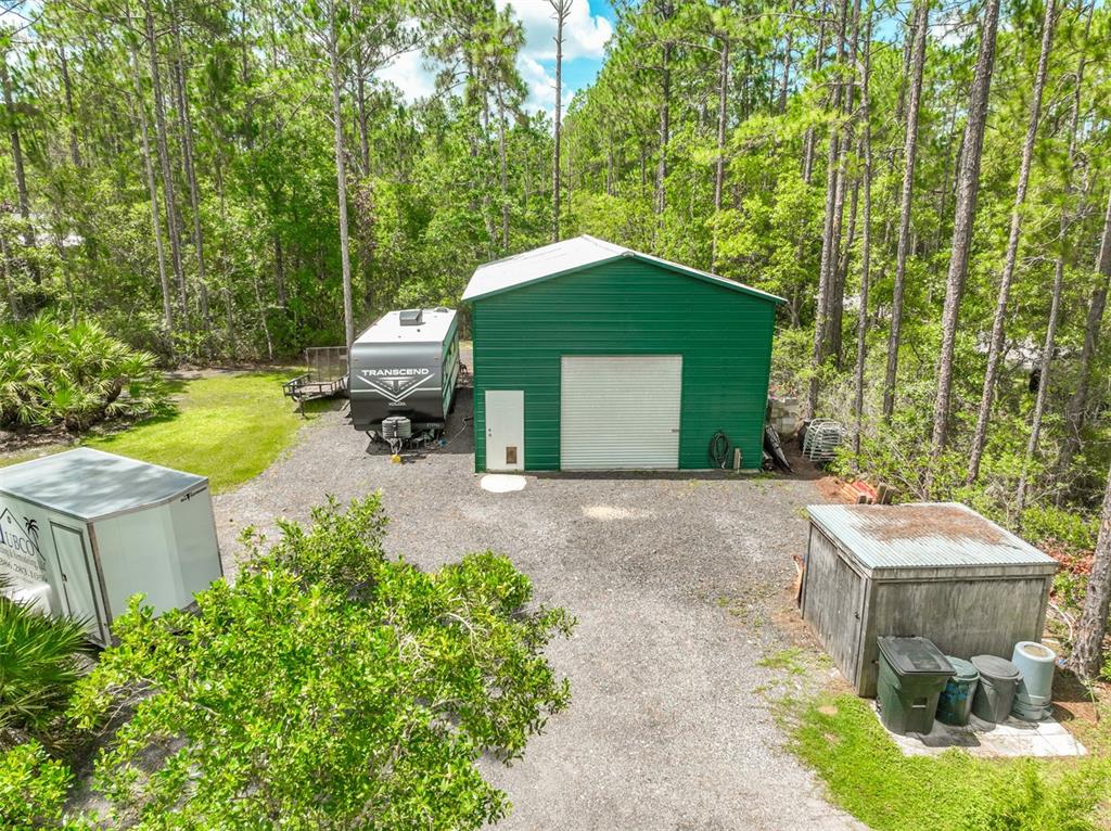 An aerial view shows a green metal workshop, a travel trailer, and a small shed — 2553 GREENTREE STREET, BUNNELL, FL