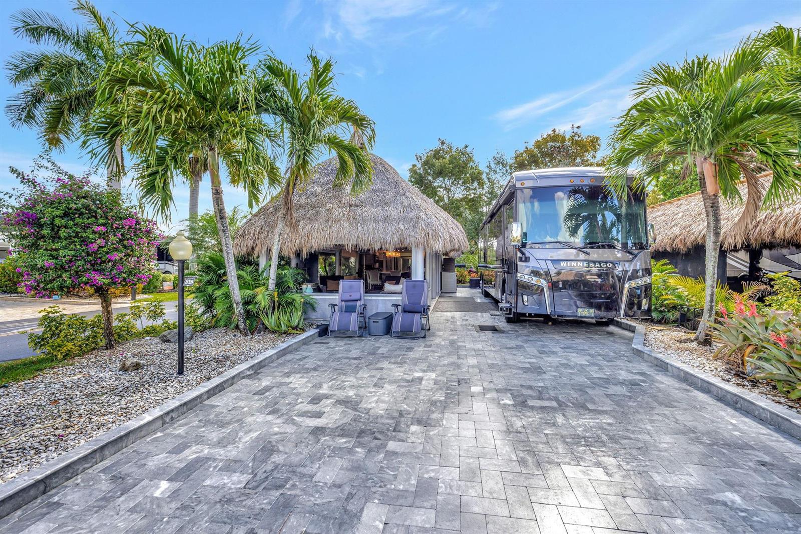 A paved driveway features a parked Winnebago motorhome next to a thatched-roof tiki hut — 58 S Carol Parkway # 58, Margate FL 33068, MARGATE, FL