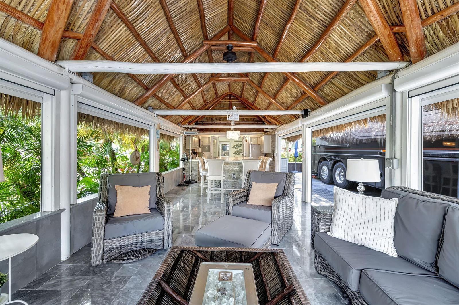 An open-air patio with a thatched roof, wicker furniture, and a view of a parked RV — 58 S Carol Parkway # 58, Margate FL 33068, MARGATE, FL
