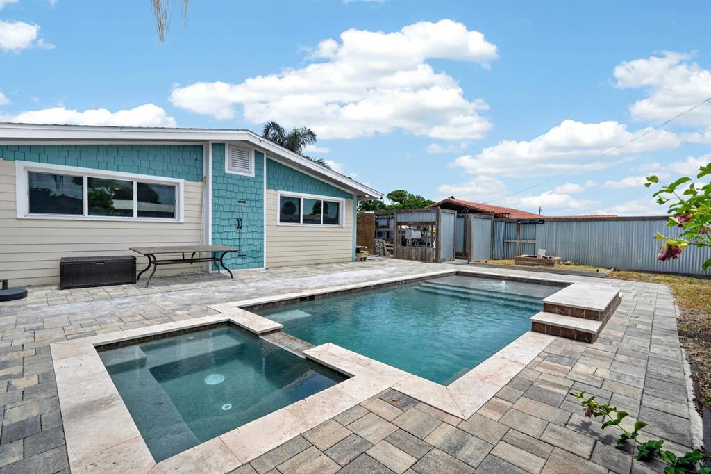 A backyard features a rectangular swimming pool, a spa, and a patio with stone pavers — 2071 S PENINSULA DRIVE, DAYTONA BEACH, FL