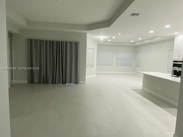 A spacious, open-concept room features light tile flooring, recessed lighting, and a large sliding door — 4624 Citrus Blossom Ct, Westlake FL 33470, WESTLAKE, FL