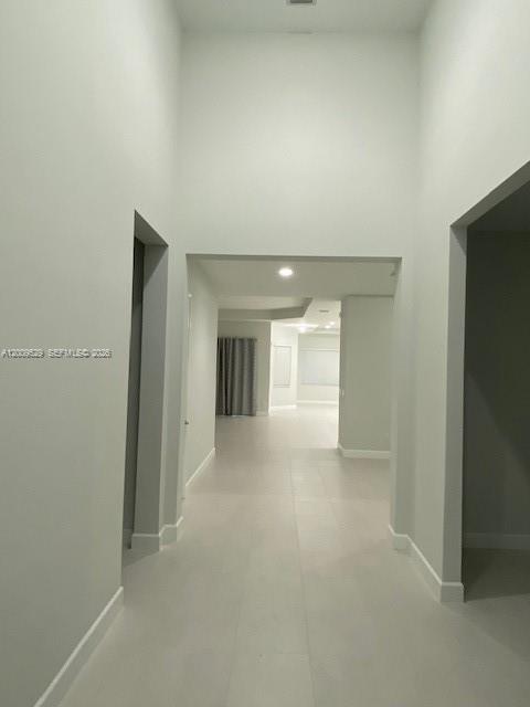 A long, high-ceilinged hallway with light tile flooring leads into an open living area — 4624 Citrus Blossom Ct, Westlake FL 33470, WESTLAKE, FL