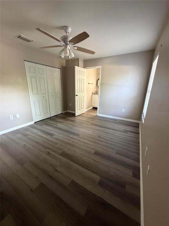A bedroom with light-colored walls, wood-look flooring, a ceiling fan, and a closet — 1088 NOMAD ROAD, PUNTA GORDA, FL