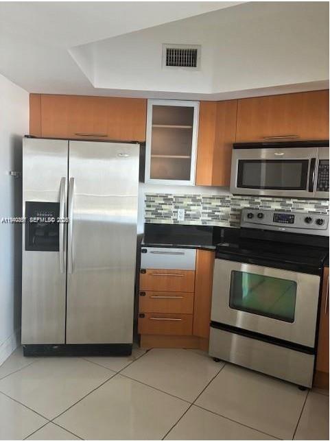 A kitchen features stainless steel appliances, light wood cabinets, and a tiled backsplash — 1750 N Bayshore Dr # 1714, Miami FL 33132, MIAMI, FL