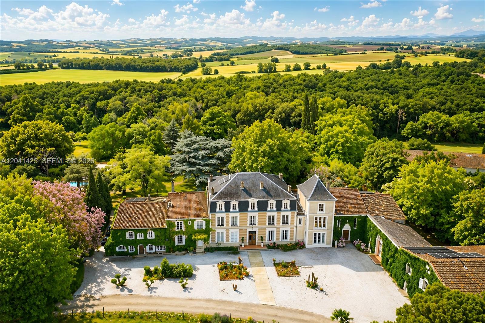An aerial view shows a large French country estate with a gravel courtyard and gardens — 1234 Mazerolles-du-Razès,, NY 11240, NY