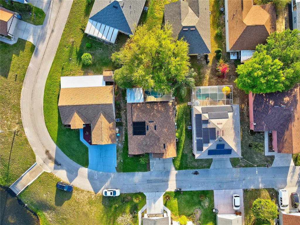 Aerial view of a residential neighborhood featuring several houses with pools and solar panels — 50989 HIGHWAY 27 UNIT 360, DAVENPORT, FL