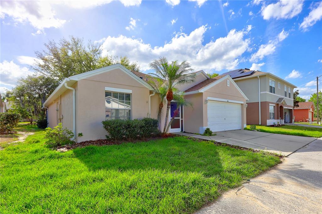 A single-story peach-colored house with a white garage and a small palm tree — 50989 HIGHWAY 27 UNIT 360, DAVENPORT, FL