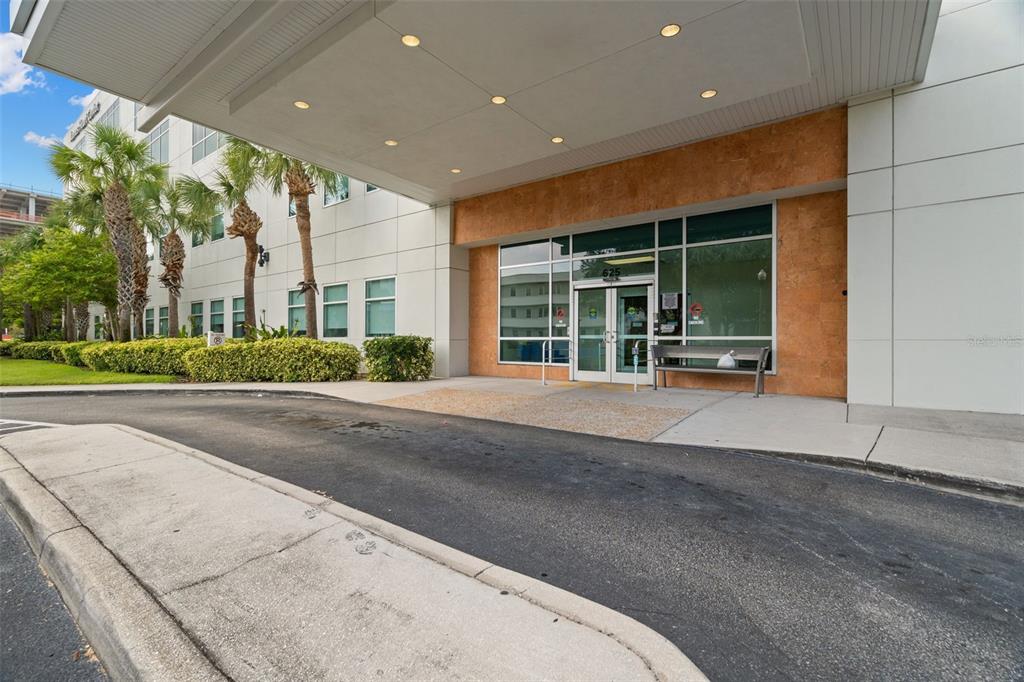 The exterior entrance of a commercial building features a covered drop-off area and glass doors — 625 6TH AVENUE S UNIT 405, ST PETERSBURG, FL