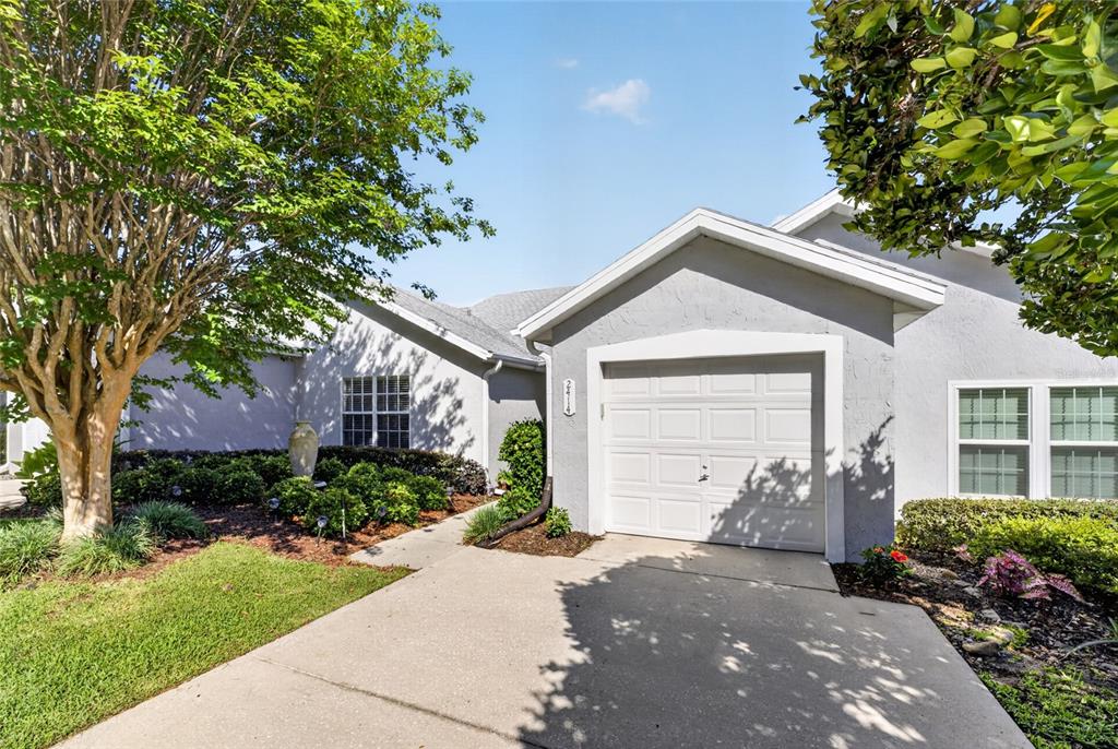 A single-story house with a white garage door, gray stucco exterior, and a concrete driveway — 2414 SW 20TH COURT, OCALA, FL