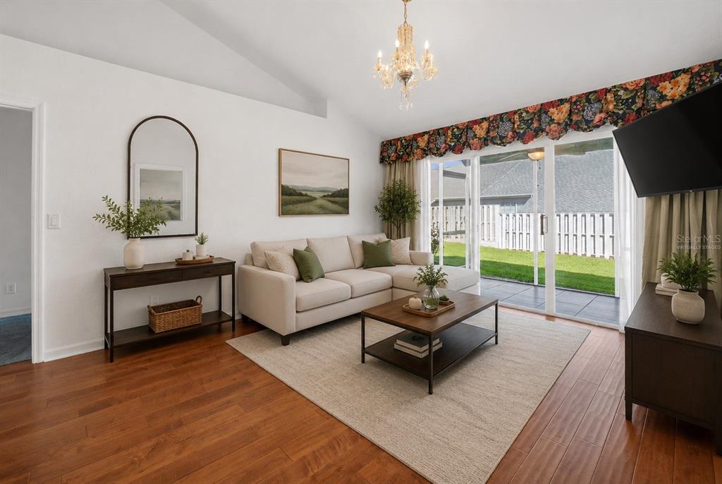 A living room features a sectional sofa, coffee table, chandelier, and sliding glass doors — 2414 SW 20TH COURT, OCALA, FL