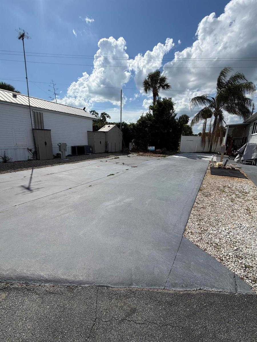 A concrete driveway sits between two mobile homes under a bright, partly cloudy sky — 7950 Fl-78, Okeechobee FL 34974, OKEECHOBEE, FL