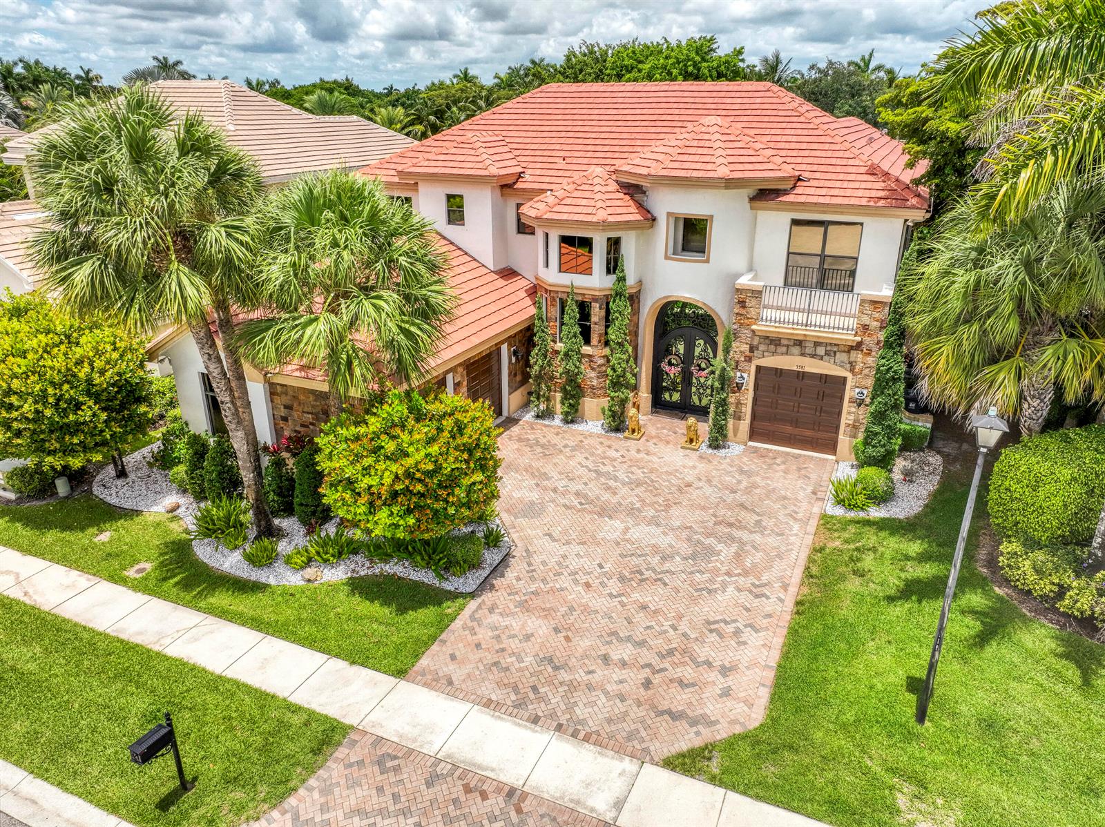 An aerial view of a two-story house with a red tile roof and brick driveway — 3581 Collonade Drive, Wellington FL 33449, WELLINGTON, FL