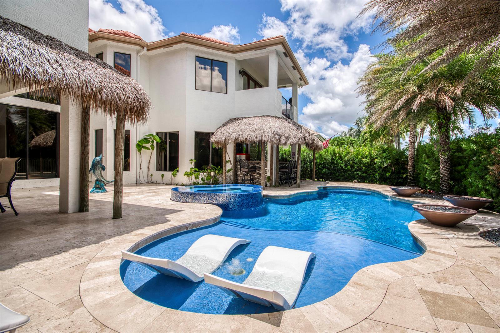 A backyard swimming pool with a spa, tanning ledge, and tiki hut patio area — 3581 Collonade Drive, Wellington FL 33449, WELLINGTON, FL