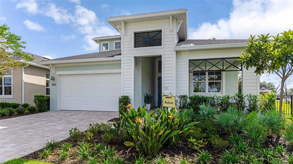 A white single-story house with a two-car garage and a landscaped front yard — 1631 LAKE RESERVE DRIVE, DELAND, FL