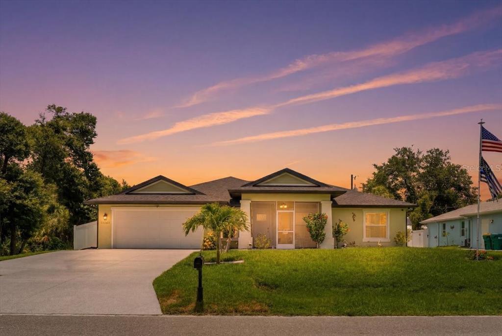 A single-story house with a two-car garage, a screened entryway, and a front lawn — 17432 SHIRLEY AVENUE, PORT CHARLOTTE, FL