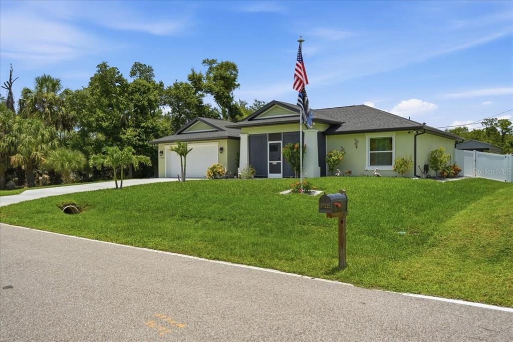 A light green single-story house with a two-car garage and a flag pole — 17432 SHIRLEY AVENUE, PORT CHARLOTTE, FL