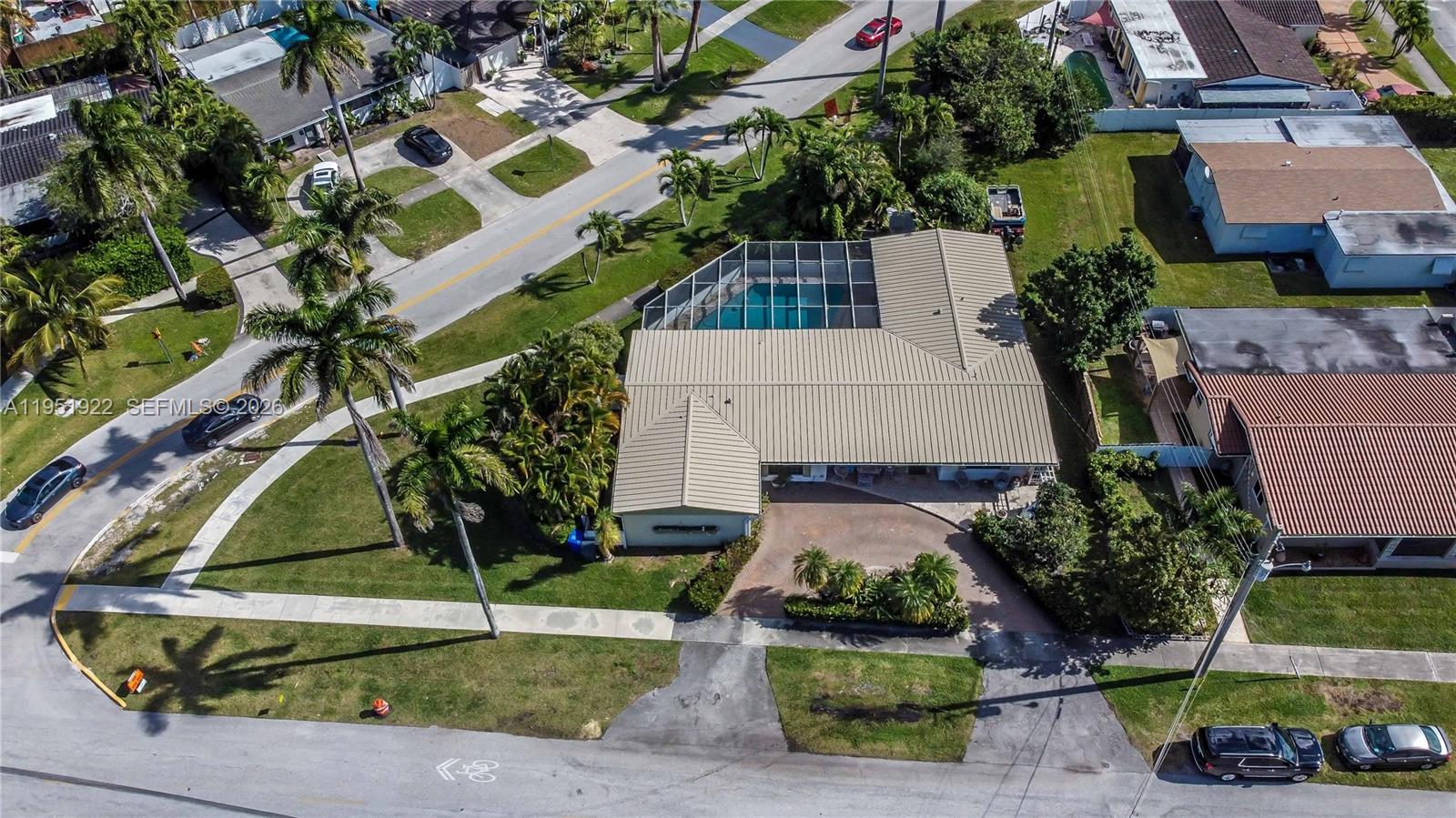 An aerial view shows a house with a metal roof and a screened-in pool — 910 N 14th Ct, Hollywood FL 33020, HOLLYWOOD, FL