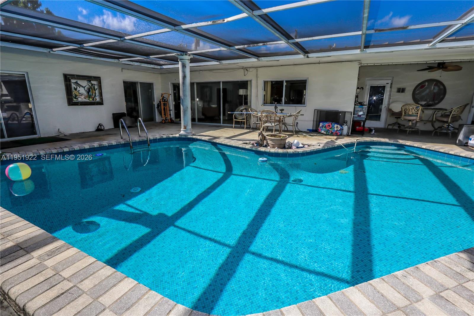 A swimming pool with a screened-in patio area and outdoor furniture — 910 N 14th Ct, Hollywood FL 33020, HOLLYWOOD, FL