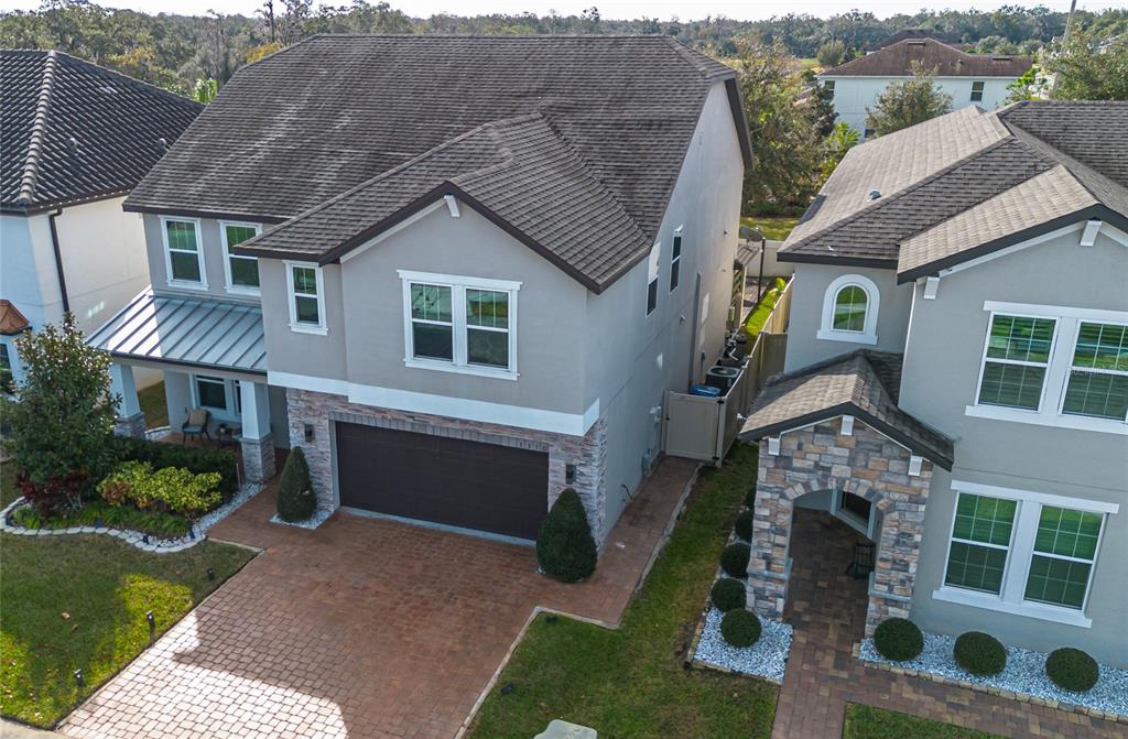 An aerial view shows two two-story suburban houses with stone accents and paved driveways — 3310 STONEWYCK STREET, ORLANDO, FL