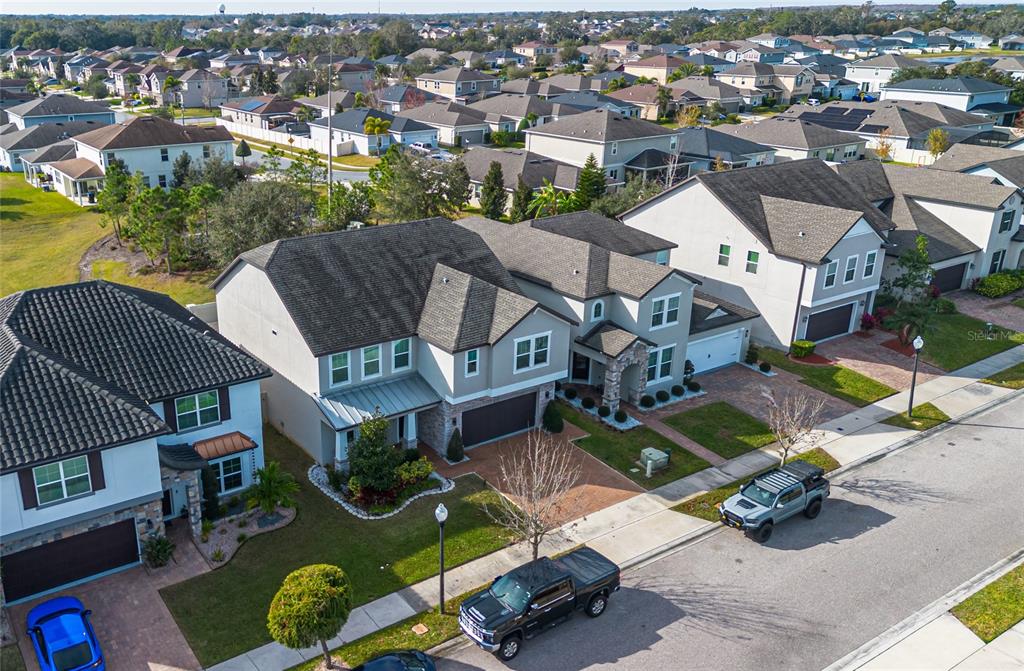 An aerial view shows suburban houses with paved driveways and parked vehicles on a street — 3310 STONEWYCK STREET, ORLANDO, FL