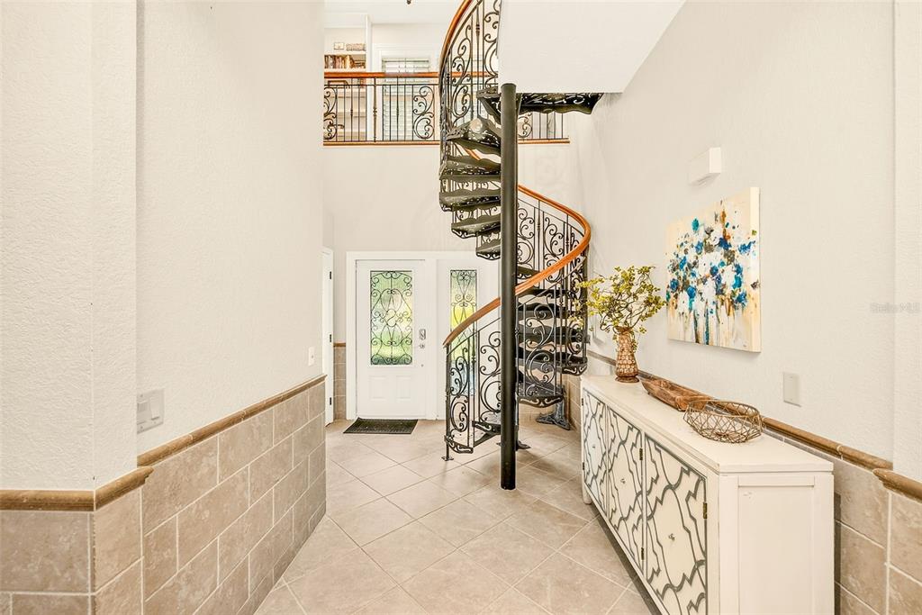 An entryway features a spiral staircase with ornate metal railings and tile flooring — 807 CENTERBROOK DRIVE, BRANDON, FL