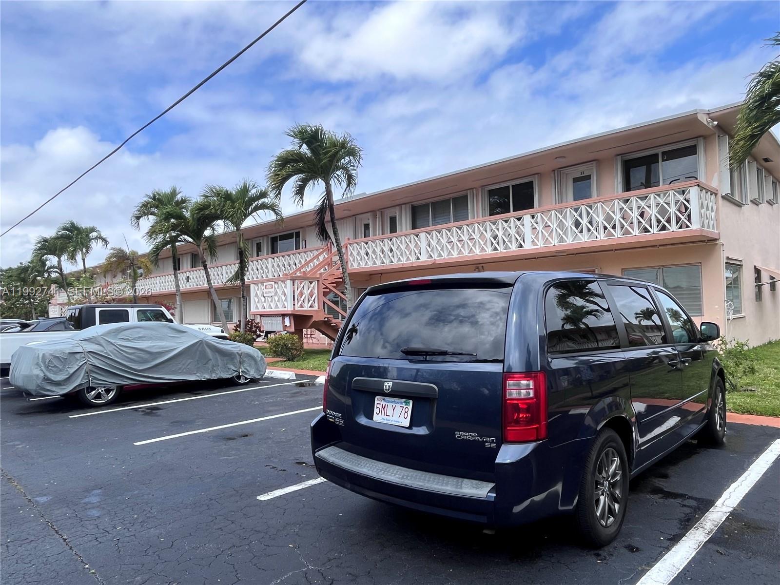 A dark blue minivan is parked in front of a two-story apartment building with balconies — 1012 SW 11th St # 9N, Hallandale Beach FL 33009, HALLANDALE BEACH, FL