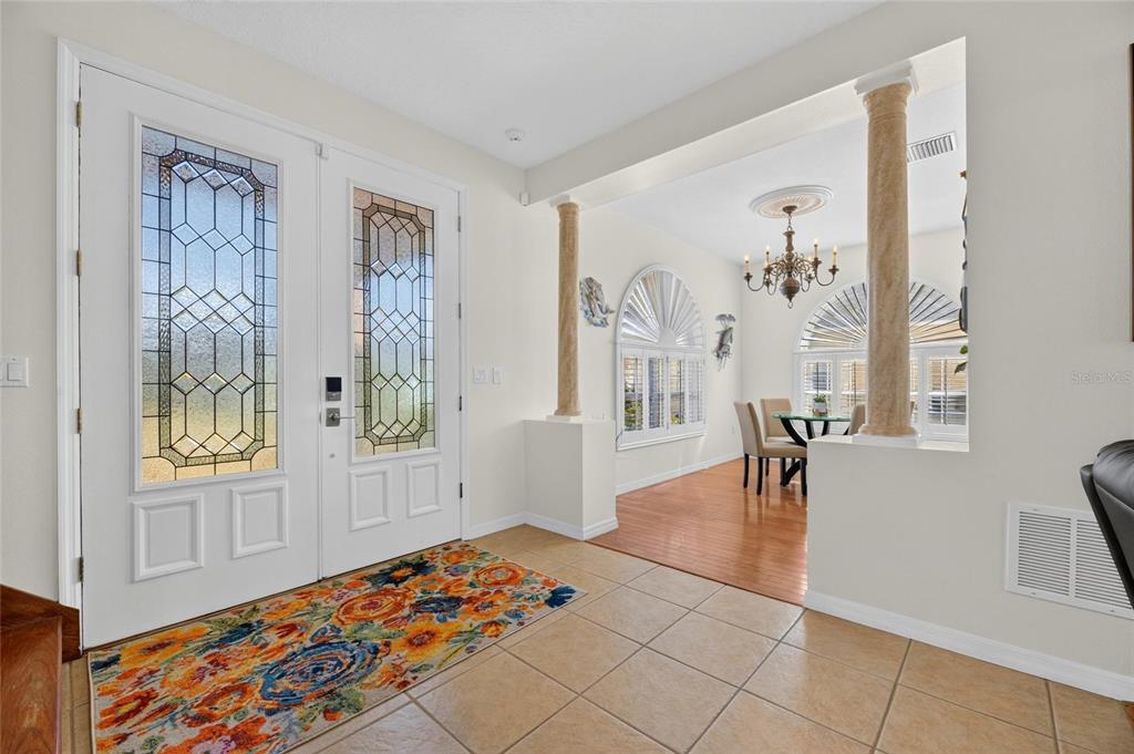 A paved front porch leads to a dark blue double door with glass inserts — 830 GOLF ISLAND DRIVE, APOLLO BEACH, FL