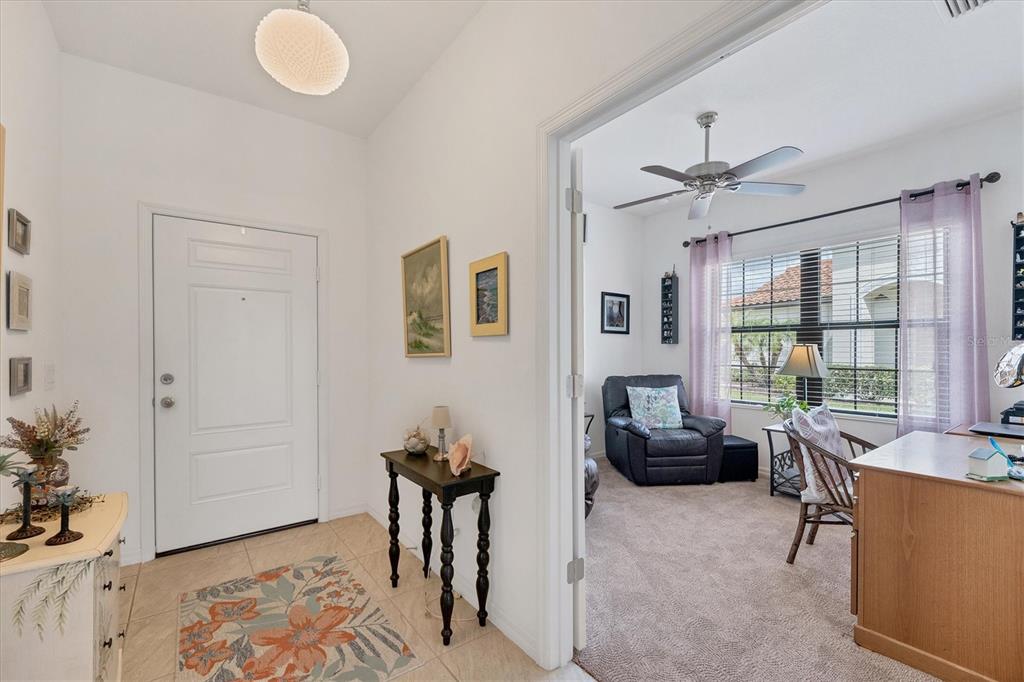 A tiled entryway leads into a carpeted office space with a ceiling fan and window — 317 ACERNO DRIVE, NOKOMIS, FL
