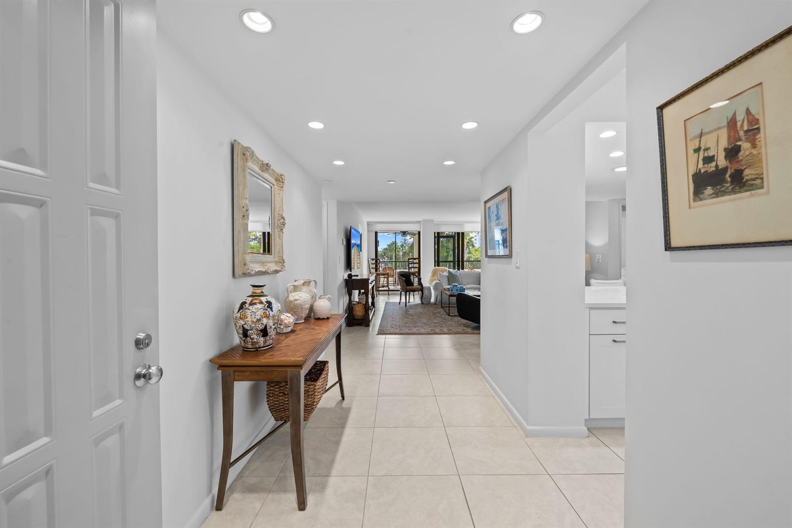 A bright kitchen features white cabinets, stainless steel appliances, gold hardware, and light tile flooring — 3420 S Ocean Boulevard # 3p, Highland Beach FL 33487, HIGHLAND BEACH, FL