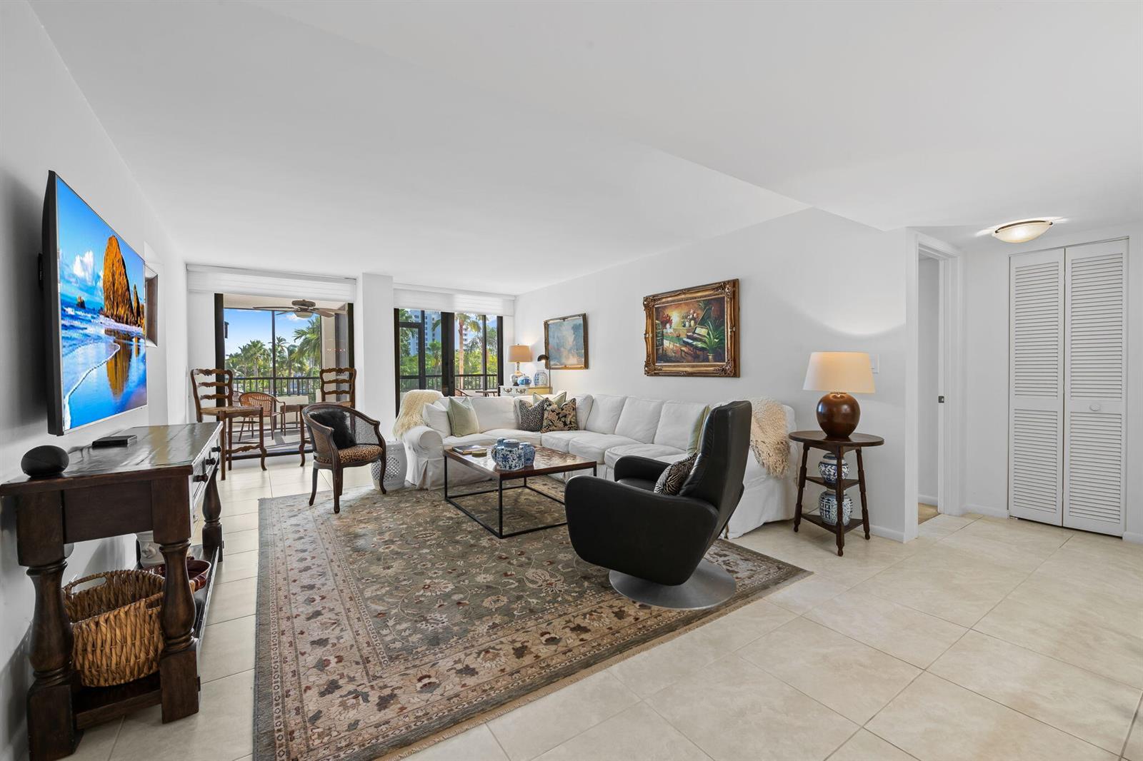 A kitchen features white cabinets, stainless steel appliances, quartz countertops, and a wooden dining set — 3420 S Ocean Boulevard # 3p, Highland Beach FL 33487, HIGHLAND BEACH, FL