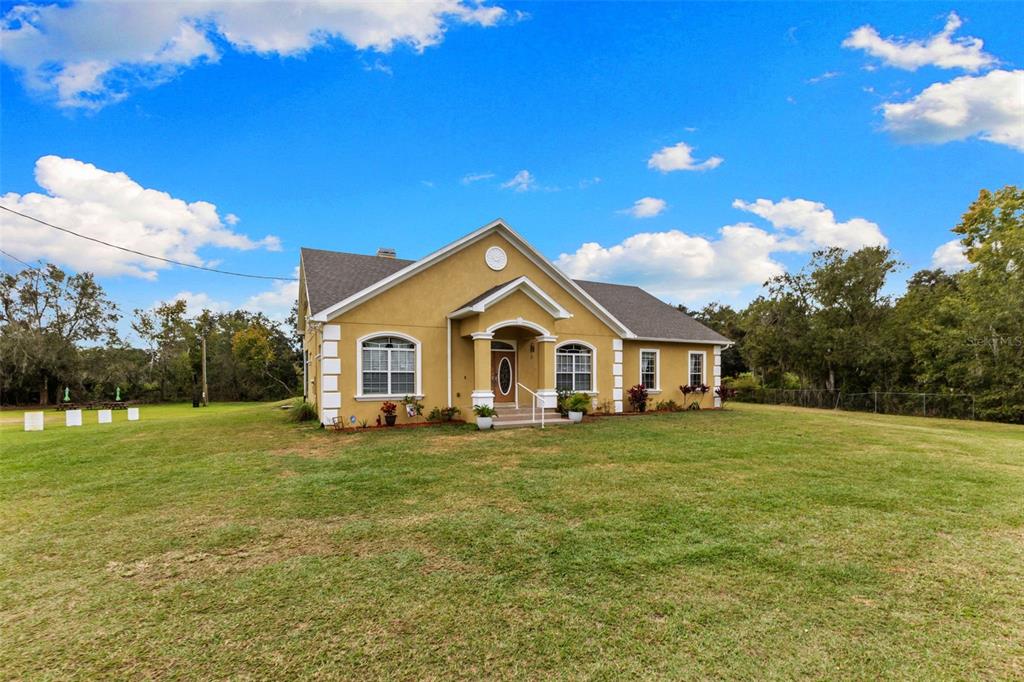 A yellow, single-story house with white trim and a front porch sits on a lawn — 1103 COLSON ROAD, PLANT CITY, FL