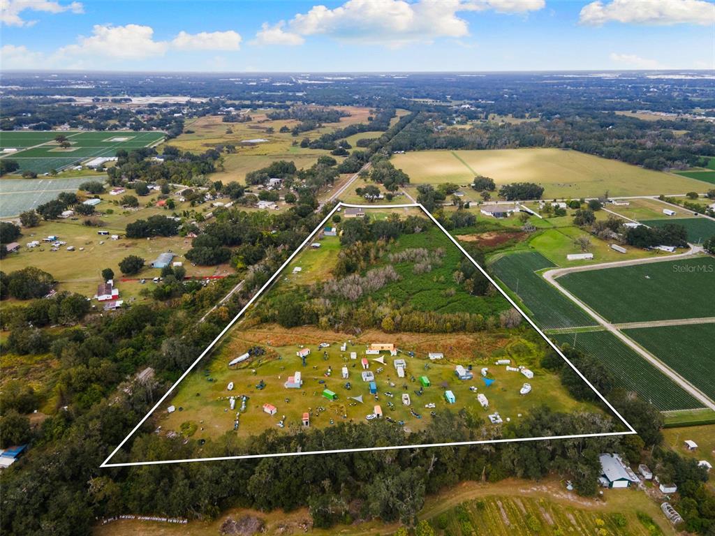 An aerial view shows a large, triangular plot of land containing numerous small structures and vehicles — 1103 COLSON ROAD, PLANT CITY, FL