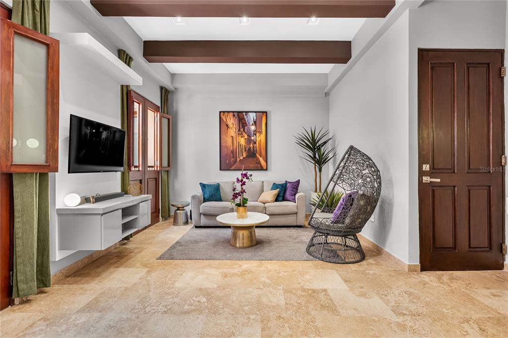 A living room features a sofa, a hanging chair, a television, and stone tile flooring — 311 LUNA ST UNIT 202, SAN JUAN, PR