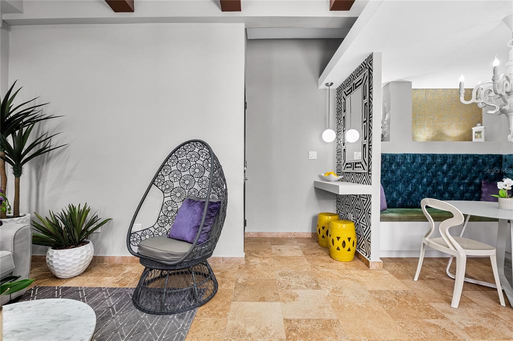 A living and dining area features a wicker egg chair, patterned wall accents, and tile flooring — 311 LUNA ST UNIT 202, SAN JUAN, PR