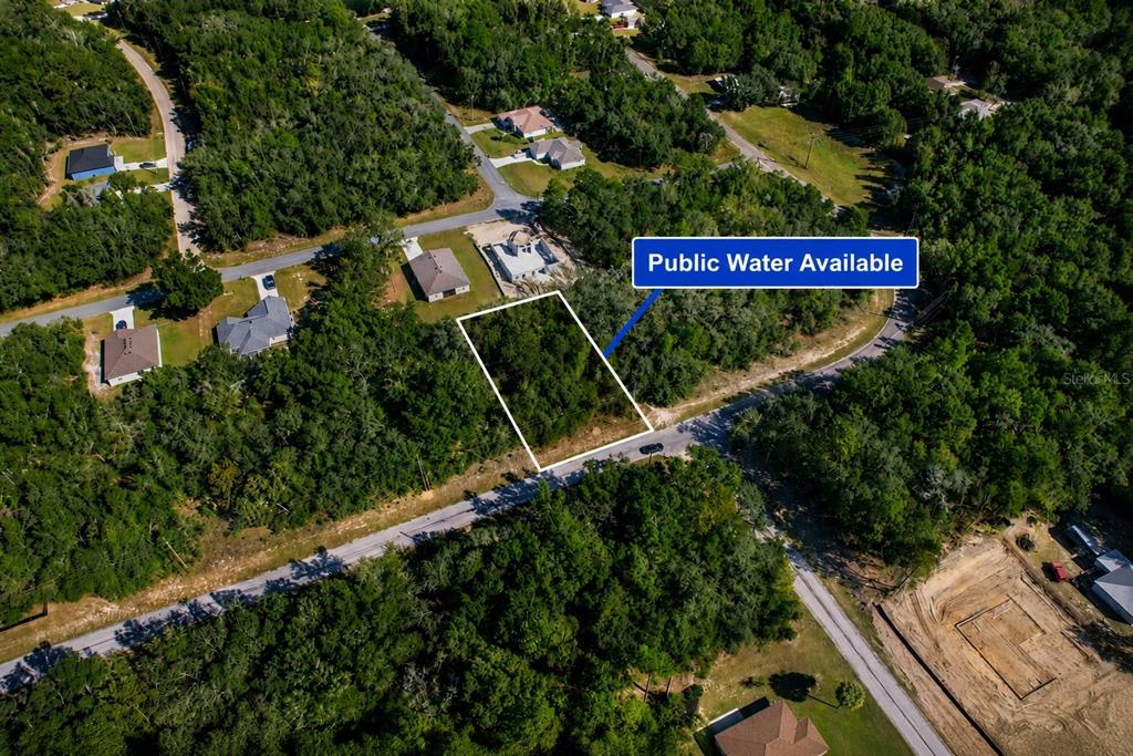 An aerial view shows a vacant, wooded residential lot outlined in white along a road — 10562 N ADLER DRIVE, CITRUS SPRINGS, FL