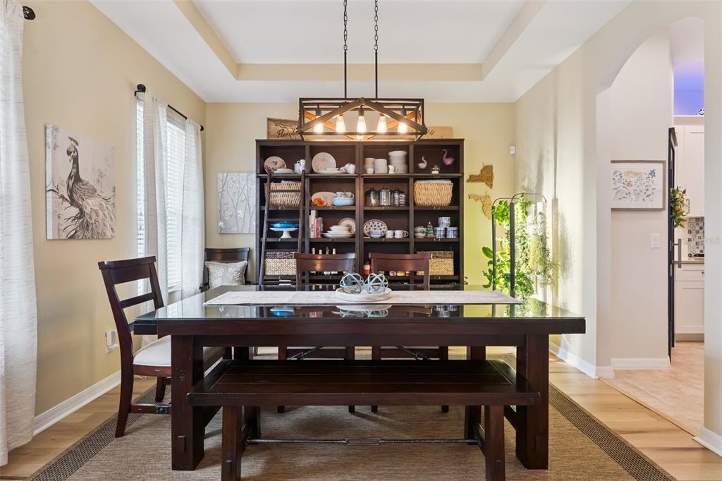 A dining room features a dark wood table, bench seating, and a large display bookshelf — 420 PARK LAKE DRIVE, WINTER SPRINGS, FL