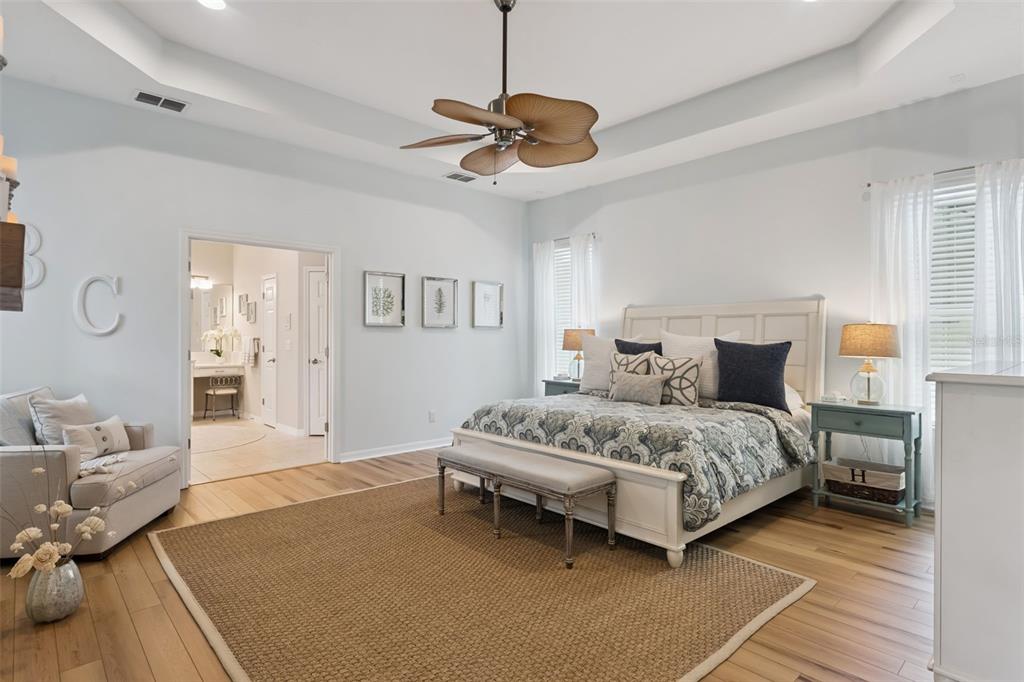 A bedroom features a white bed, a ceiling fan, light wood floors, and an area rug — 420 PARK LAKE DRIVE, WINTER SPRINGS, FL
