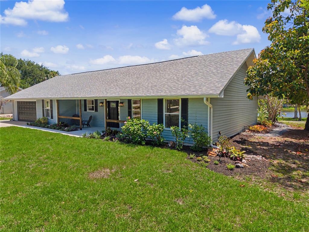 A light blue single-story house with a gray shingled roof and a front porch — 601 136TH COURT E, BRADENTON, FL
