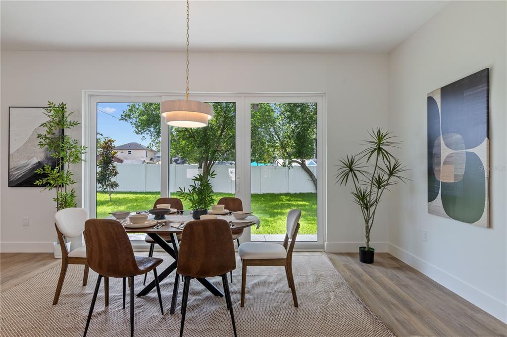 A dining room features a round table, six chairs, a pendant light, and sliding glass doors — 6710 N 17TH STREET, TAMPA, FL